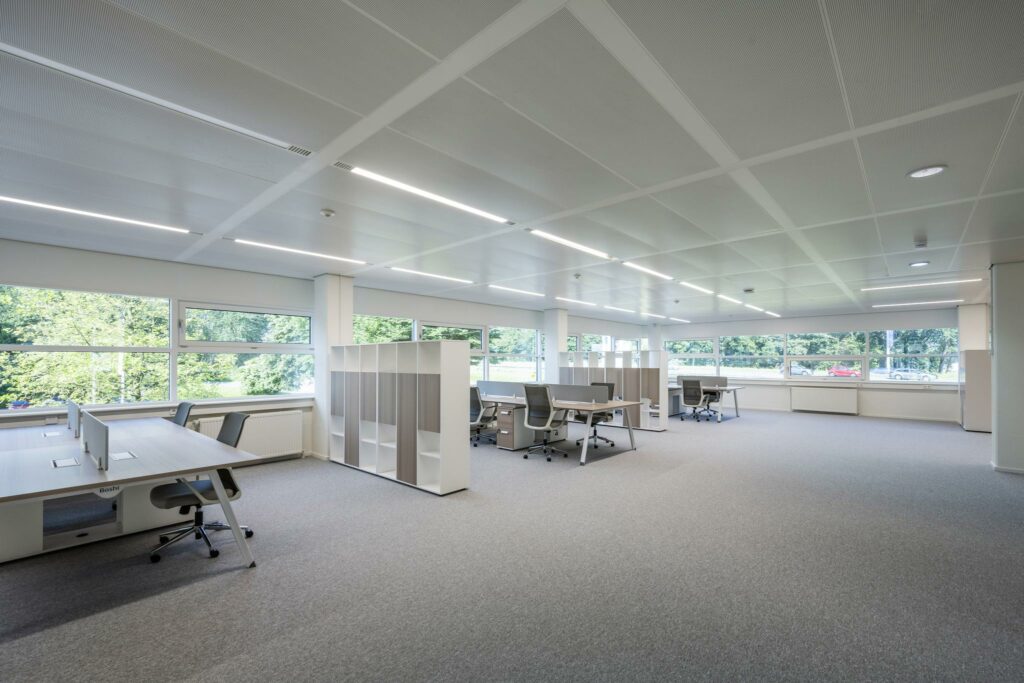 Ruim en licht modern kantoorinterieur aan de Burgemeester Stramanweg met meerdere werkplekken en grote ramen.